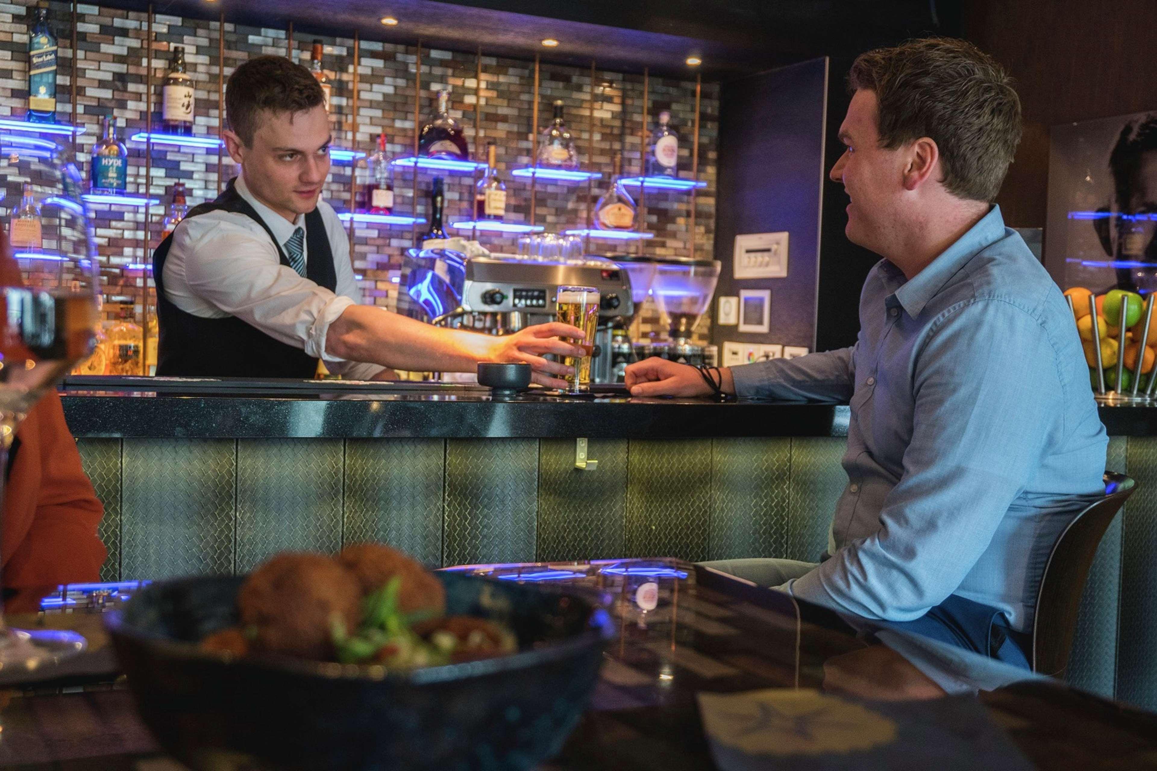힐튼 더 헤이그 외부 사진 A bartender serving a customer